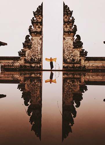 jl. pura telaga mas lempuyang person in yellow scarf standing between two gray concrete structures tri buana